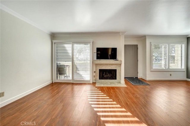 unfurnished living room featuring hardwood / wood-style flooring, a high end fireplace, and ornamental molding