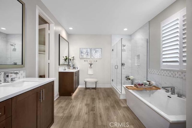 bathroom featuring separate shower and tub, vanity, wood-type flooring, and a healthy amount of sunlight