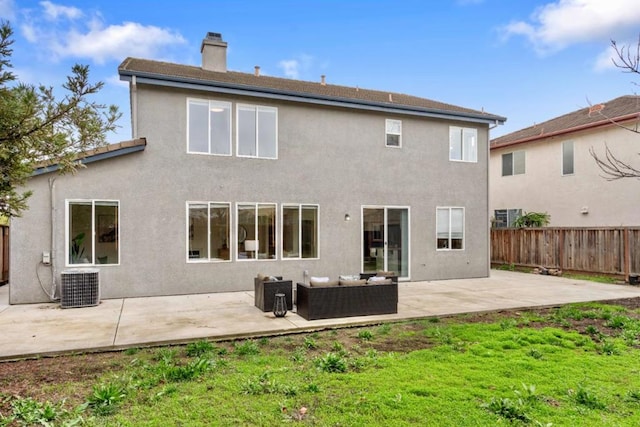 back of house with a yard, a patio, an outdoor living space, and central AC