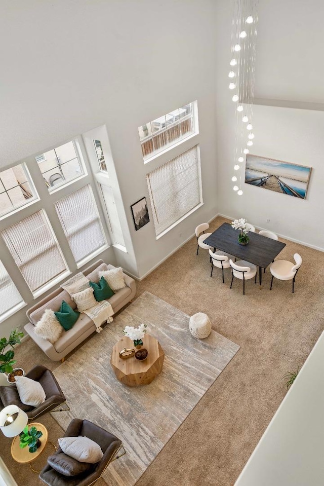 living room featuring carpet and a towering ceiling