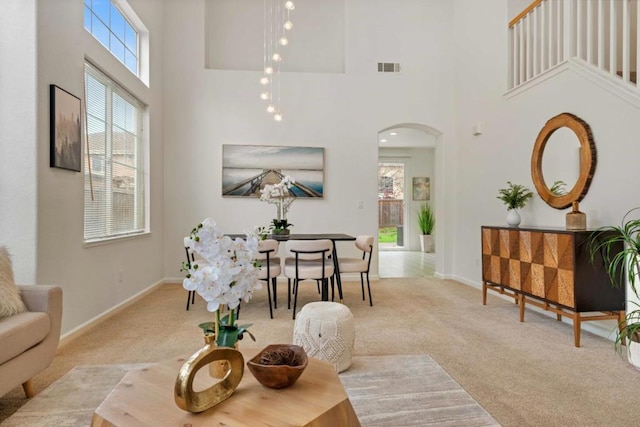 living room with light colored carpet and a towering ceiling