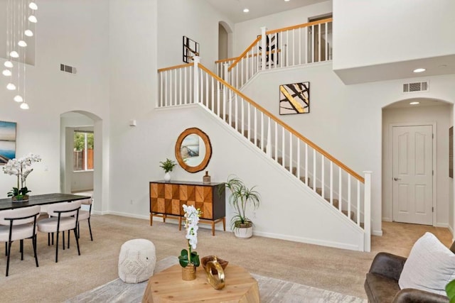 carpeted living room featuring a high ceiling