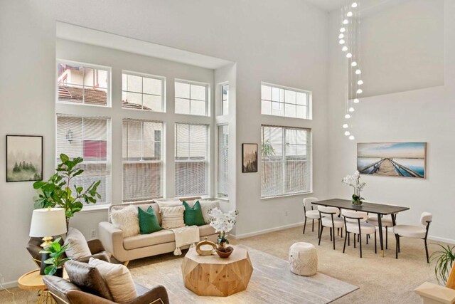 carpeted living room with a healthy amount of sunlight and a towering ceiling