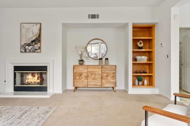 living area with built in features and carpet floors