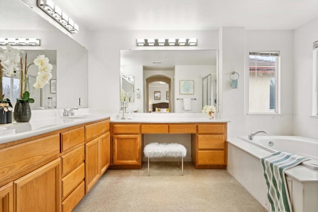 bathroom featuring shower with separate bathtub and vanity