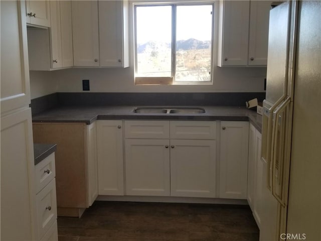 31072 Azurite Rd, Lucerne Valley, CA 92356 - kitchen featuring a sink, freestanding refrigerator, white cabinetry, dark wood finished floors, and dark countertops