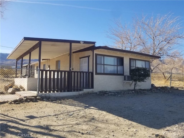 view of property exterior featuring stucco siding and fence