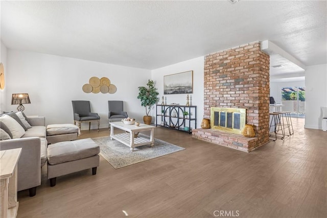 living room featuring dark hardwood / wood-style flooring and a brick fireplace