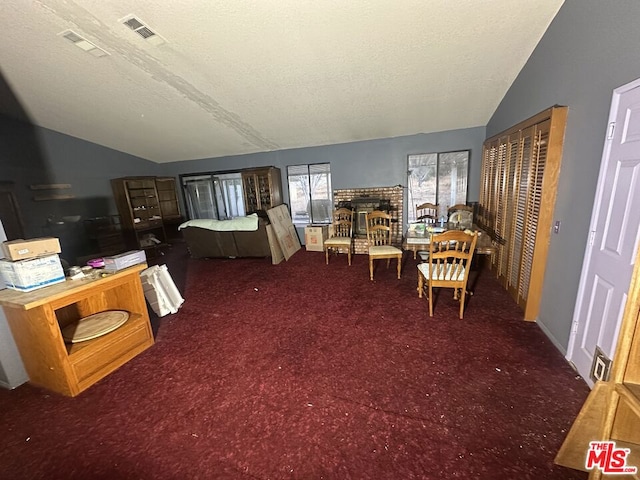 carpeted bedroom with vaulted ceiling and a textured ceiling