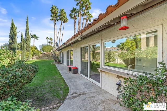 view of property exterior featuring a lawn and a patio