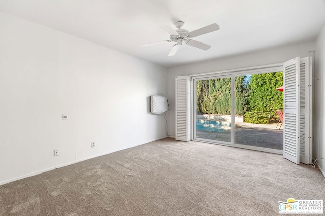 unfurnished room with ceiling fan and carpet