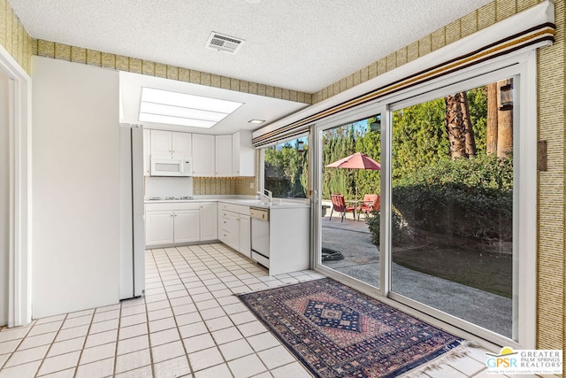 kitchen featuring white cabinetry, sink, white appliances, and a textured ceiling