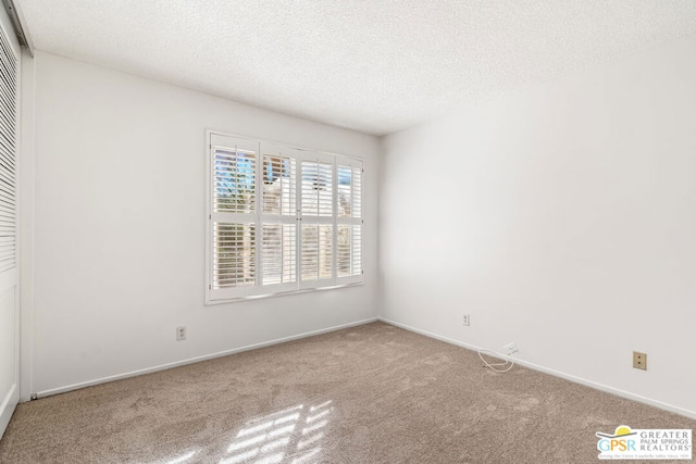 carpeted spare room featuring a textured ceiling