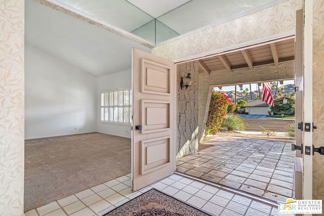 entrance foyer featuring light colored carpet and vaulted ceiling