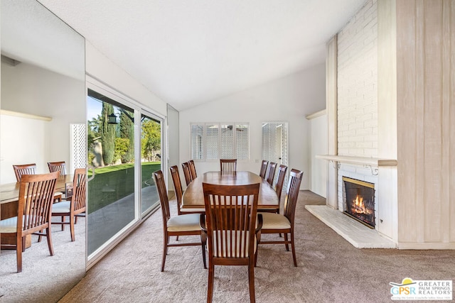 dining space with high vaulted ceiling, carpet, and a fireplace