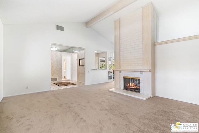 unfurnished living room with light carpet, a fireplace, beamed ceiling, and high vaulted ceiling