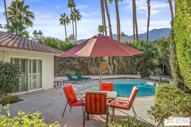 view of swimming pool with a mountain view and a patio