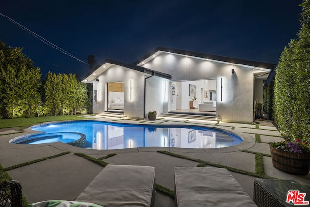 pool at twilight with a patio area