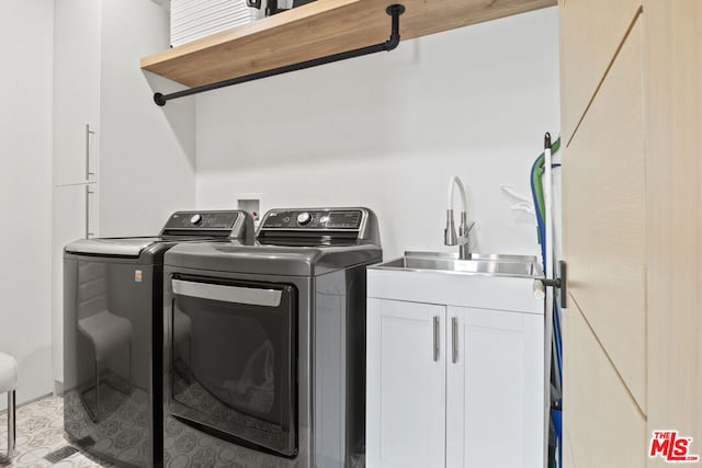 laundry room with washer and clothes dryer, sink, and cabinets