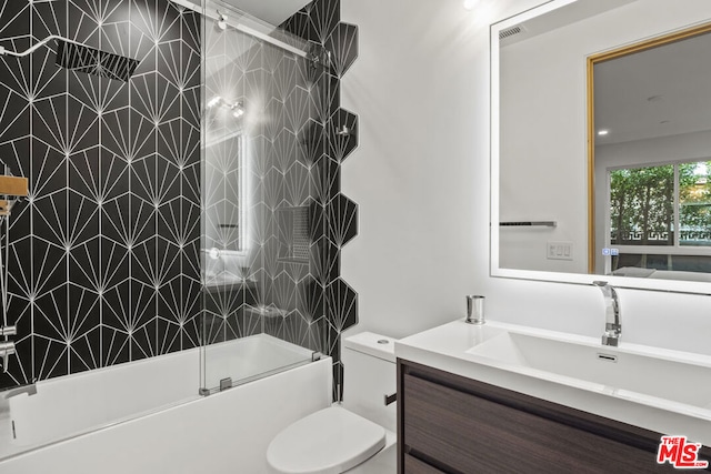 full bathroom featuring toilet, bath / shower combo with glass door, and vanity