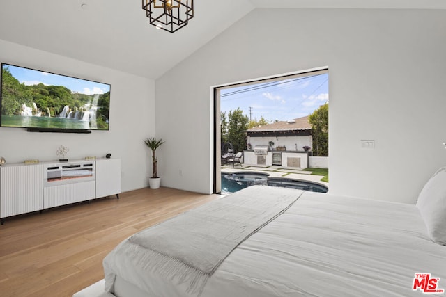 bedroom with high vaulted ceiling, light wood-type flooring, and an inviting chandelier