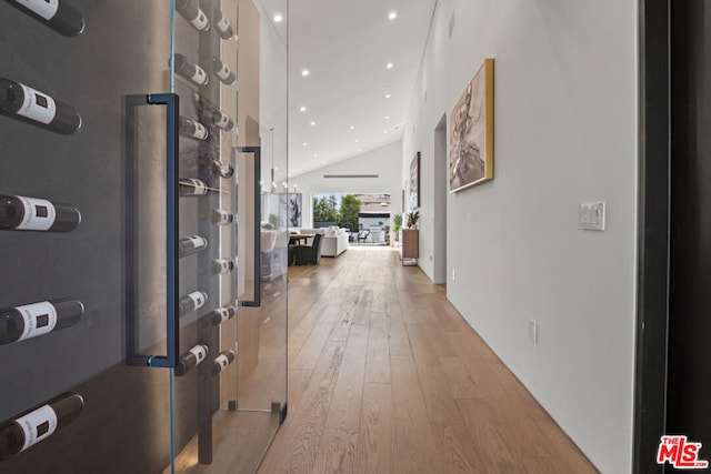 hall with vaulted ceiling and light wood-type flooring