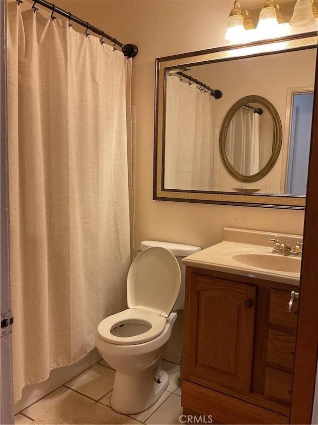 bathroom featuring toilet, tile patterned flooring, walk in shower, and vanity