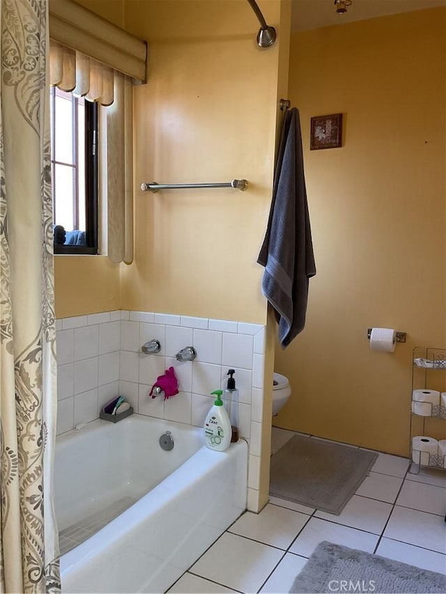 bathroom with toilet, a bathtub, and tile patterned floors