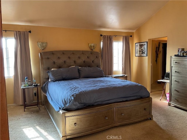 carpeted bedroom featuring vaulted ceiling and multiple windows