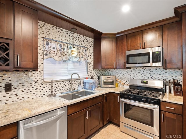 kitchen featuring tasteful backsplash, sink, light stone counters, and stainless steel appliances