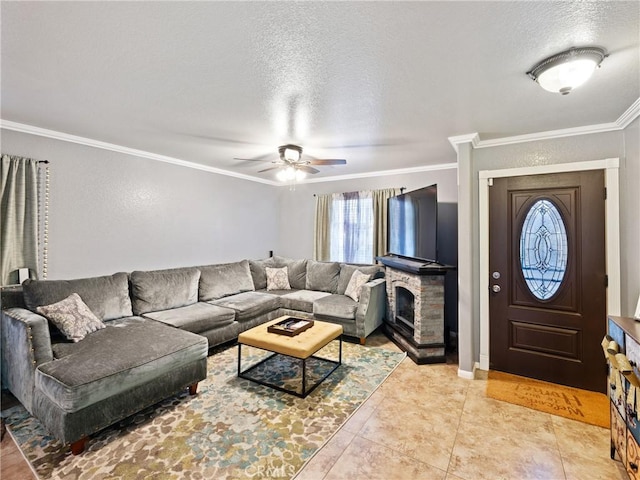 tiled living room with a textured ceiling, ceiling fan, crown molding, and a fireplace