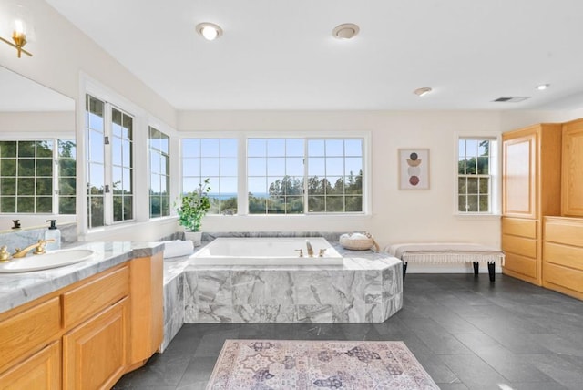 bathroom featuring tile patterned floors, vanity, and tiled tub