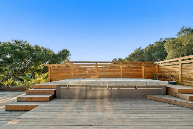 wooden deck with a covered hot tub