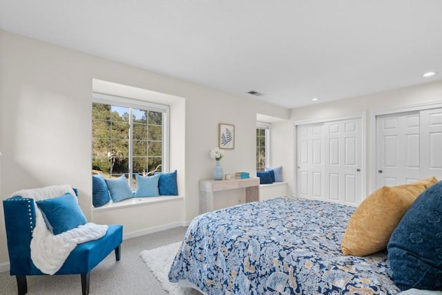 bedroom featuring multiple closets and carpet flooring