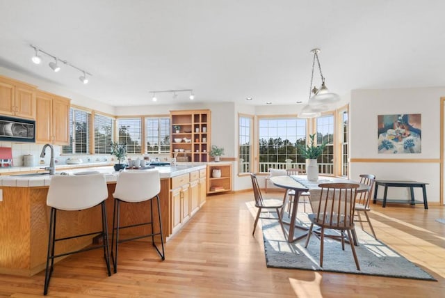 kitchen featuring pendant lighting, a healthy amount of sunlight, tile countertops, and sink