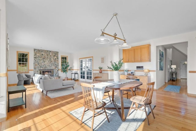 dining area featuring a fireplace and light wood-type flooring