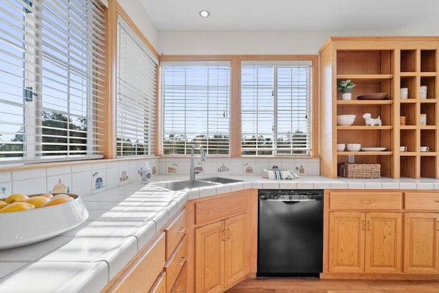 kitchen with sink, a wealth of natural light, tile counters, and black dishwasher