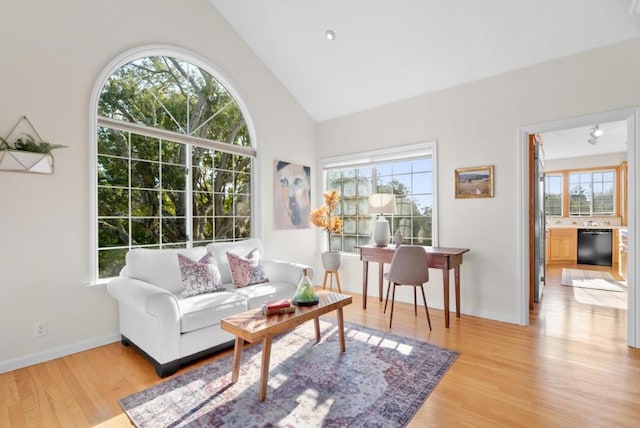 interior space featuring plenty of natural light, lofted ceiling, and light hardwood / wood-style flooring