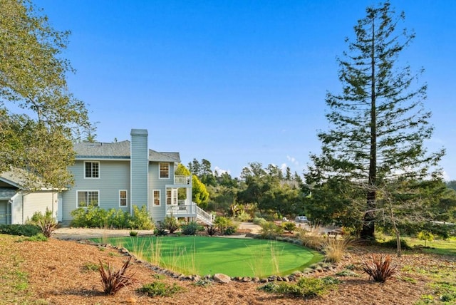 back of property featuring a lawn and a balcony