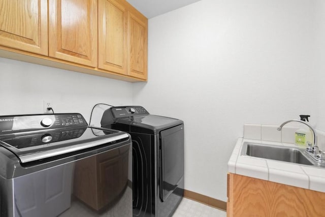 washroom with cabinets, sink, and independent washer and dryer