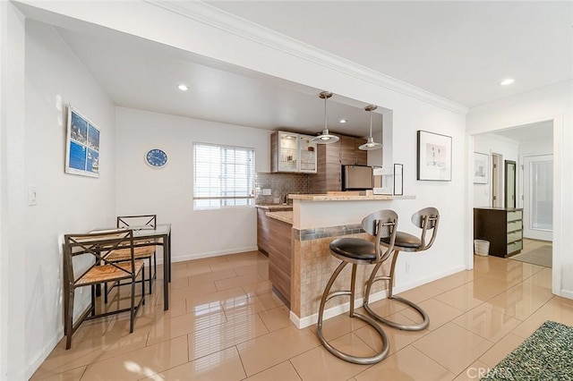 kitchen with decorative light fixtures, stainless steel fridge, light tile patterned floors, and kitchen peninsula