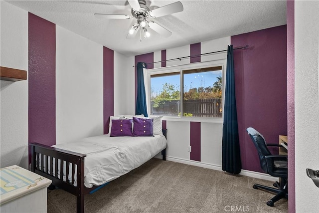 carpeted bedroom with ceiling fan and a textured ceiling