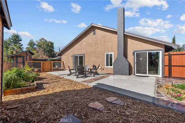 rear view of house featuring a shed and a patio area