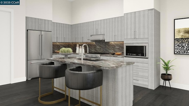 kitchen with premium range hood, a kitchen bar, high end fridge, dark hardwood / wood-style flooring, and a towering ceiling