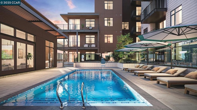 pool at dusk featuring a patio