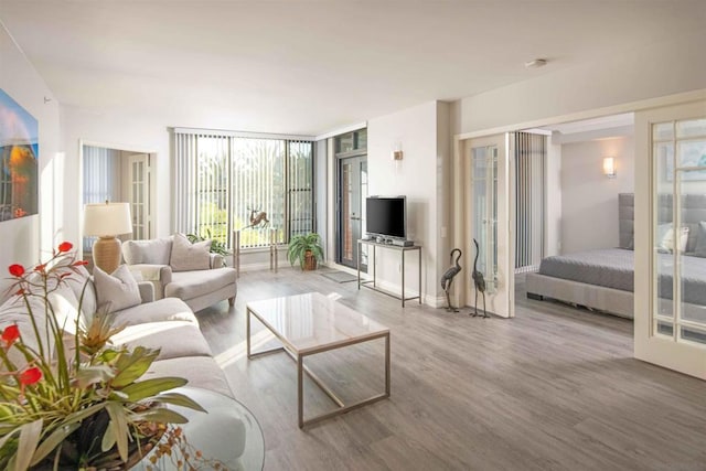 living room featuring french doors, floor to ceiling windows, and light hardwood / wood-style floors