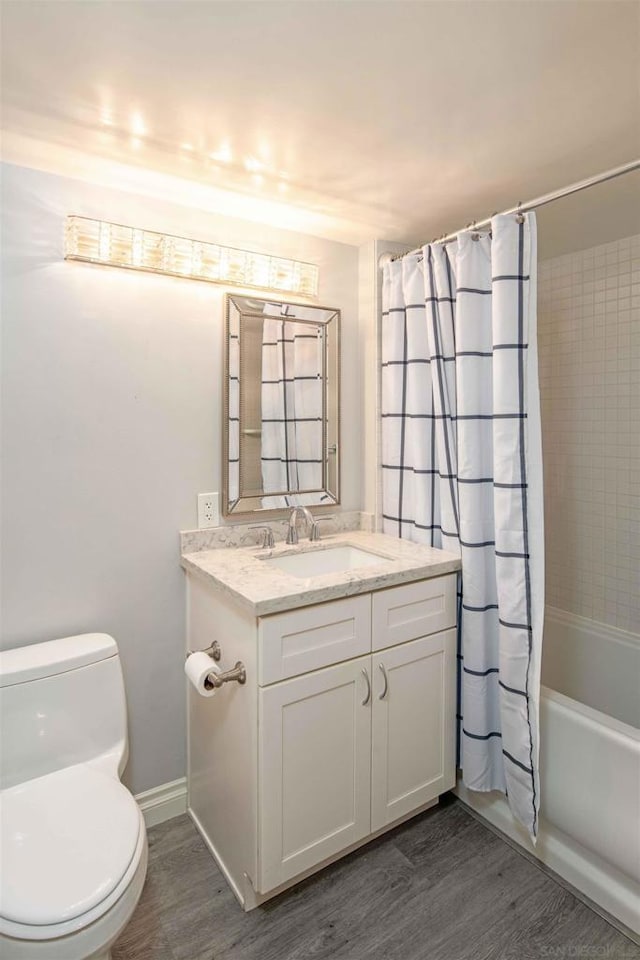 full bathroom featuring toilet, shower / tub combo, wood-type flooring, and vanity