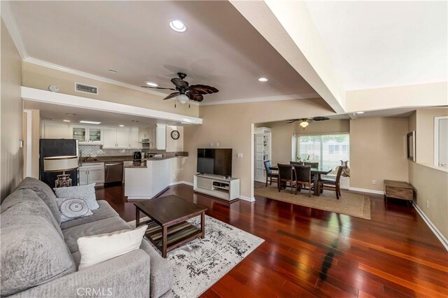 living room featuring ceiling fan, beam ceiling, dark hardwood / wood-style flooring, and ornamental molding