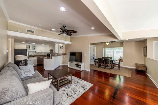 living room featuring ceiling fan, beam ceiling, dark hardwood / wood-style floors, and crown molding