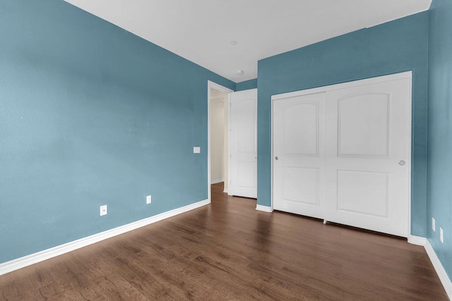 unfurnished bedroom featuring a closet and dark hardwood / wood-style floors